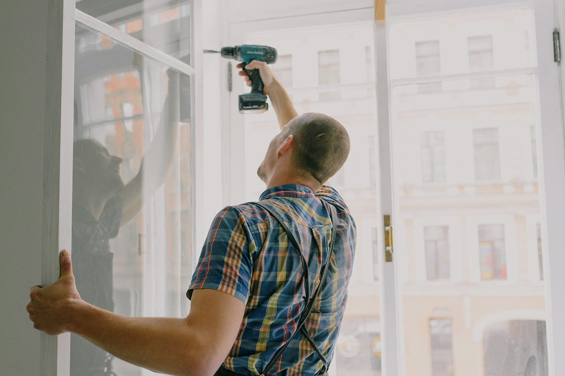 A Handyman Is Repairing A Window